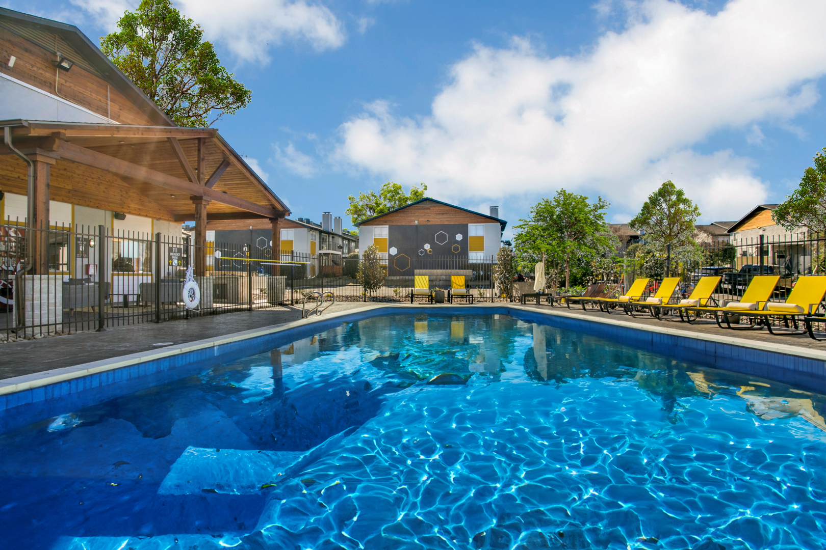 a pool with lounge chairs and umbrellas at The  Hive