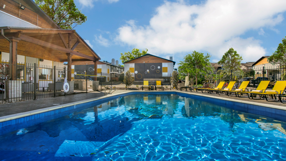 a pool with lounge chairs and umbrellas at The  Hive